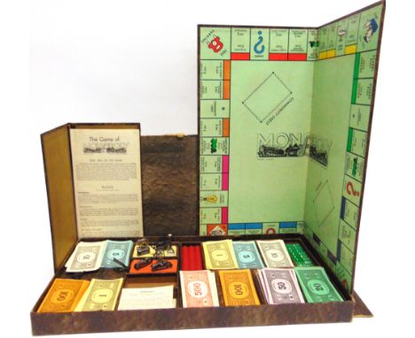 A MONOPOLY DE LUXE PRESENTATION BOARD GAME, 1936 in a snakeskin-effect box, with eight metal playing pieces, Bakelite houses 