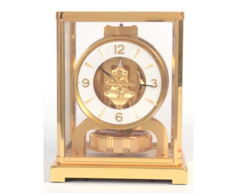 A JAEGER-LECOULTRE ATMOS CLOCK with a gilt brass framed case with hinged front door enclosing a skeletonised chapter ring wit