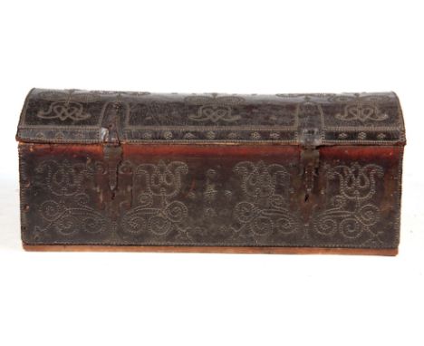 A 17TH CENTURY BRASS STUDDED LEATHER BOUND DOME-TOP TRUNK OF LARGE SIZE with ornate iron strapwork hinges and shaped lock pla