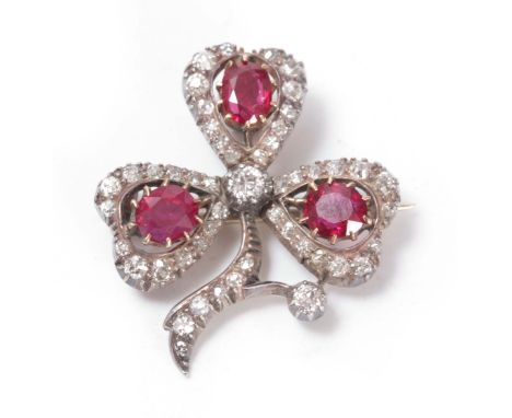 A VINTAGE PLATINUM RUBY AND DIAMOND THREE LEAF CLOVER BROOCH/PENDANT inset with three oval rubies app. 2.8ct surrounding a di