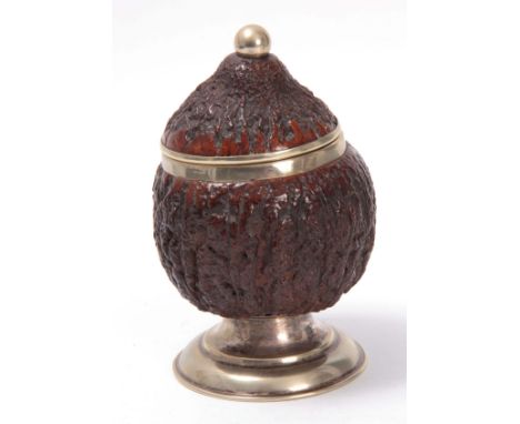 AN EARLY 20TH CENTURY NICKLE MOUNTED COCONUT TEA CADDY having a hinged lid with ball finial revealing a silverplated interior