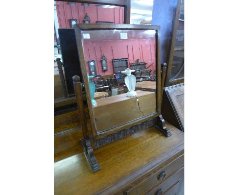 A carved oak dressing table mirror