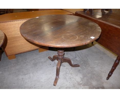 A George III oak circular tilt-top tripod table