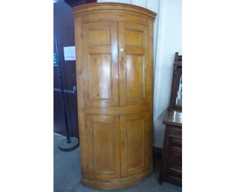 A Victorian pine bow-front freestanding corner cupboard