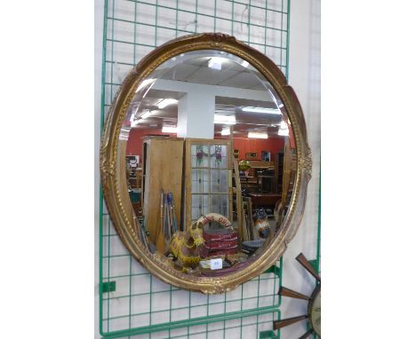 A gilt framed oval mirror