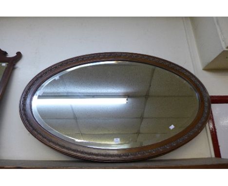 A large Edward VII carved walnut oval mirror