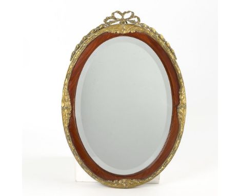 Ovaler Spiegel. Um 1900.             Bronze, Mahagoni massiv, facettiertes Spiegelglas. Lichtmaß 40 x 28 cm, Gesamtmaß 51 x 3