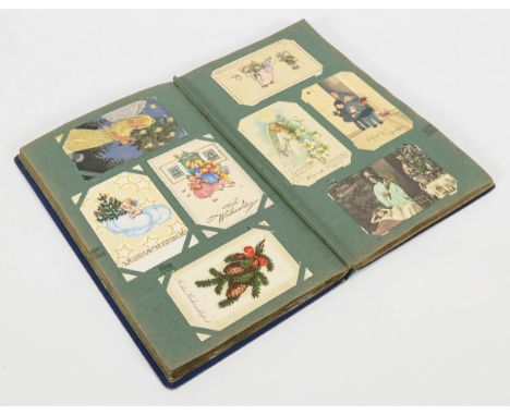 Postkartenalbum mit Weihnachts- und Neujahrskarten.             38,5 x 23 cm.             Ca. 155 Weihnachts- und 52 Neujahrs