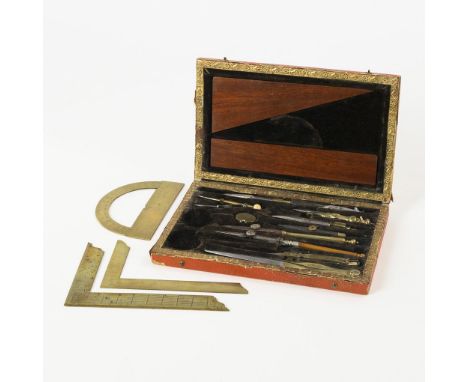 Zirkelkasten. 19. Jh.             Holzschatulle mit rotem Kaliko-Bezug und goldfarbenen Papierauflagen. Geräte aus Messing, E