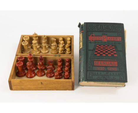 Schachspiel aus Tagua-Nuss im Kasten, dazu Schachbuch.             Taguanuss teils rot gefärbt, Holzschatulle, Buch mit Leine
