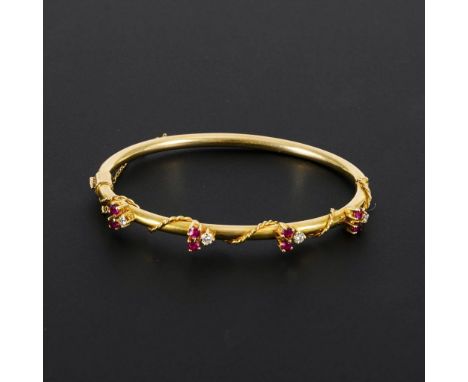 Armreif mit Rubinen und Brillanten.  Gelbgold 14 k gestempelt, geprüft. Ø 5,5 cm. 10,7 g. Ovaler Klappreif mit schauseitig 8 