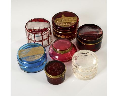 6 Ansichtendöschen und 1 Andenkendöschen. 2. H. 19. Jh.             Farbloses, 4x rot gebeiztes Glas, 1x hellblaues Glas, 1x 