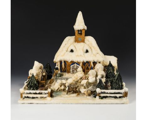 Winterlandschaft mit beleuchteter Kirche und Spieluhr.             Holz, Pappe, Watte etc. 42 x 52 x 40,5 cm.             Kle