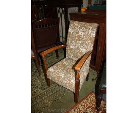 A circa 1930 Oak framed Armchair, having padded back with brass nailed upholstery, flat arms on turned supports, in floral ta
