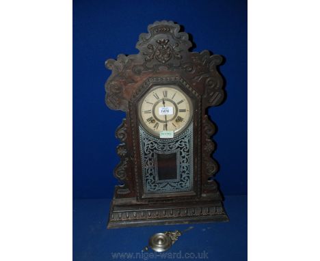 A circa 1900 American mantle Clock, carved and shaped upright case with carved frame single pane door with decorated glass, o