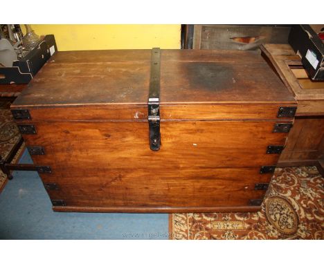 A large late 19th/early 20th century Camphorwood, iron bound Trunk having two plank top with heavy iron strap lock, opening t