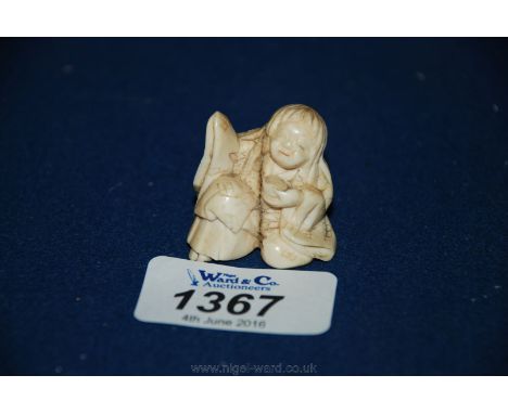 A Meiji period (circa 1870-80) Netsuke, carved from a single piece of ivory in the form of a half kneeling figure of a beggar