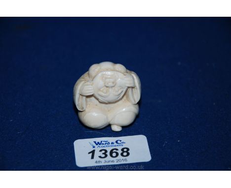 A signed Meiji period, circa 1880, Netsuke, carved from a single piece of Ivory, in the form of a squatting figure holding a 