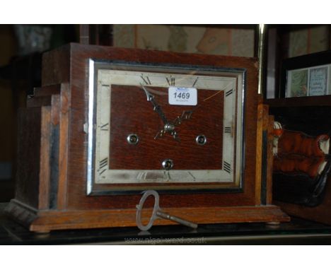 A deco style Oak cased mantle Clock, of rectangular form with triple steeped sides and on lower moulding, applied square form