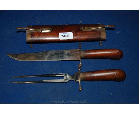 An ornamental Oriental wooden sheathed carving Knife and Fork, having oval wooden sheath on brass legs with upper brass catch