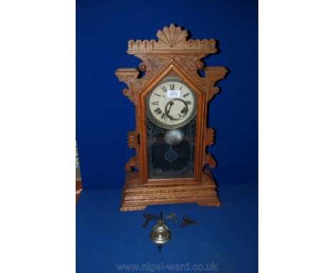 A medium Oak gingerbread kitchen mantle Clock, with architectural, carved, fret cut and pierced upright case with pointed top