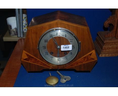 A deco Walnut cased mantle Clock in seven sided case with burr Walnut inlaid front, having alloy Arabic numeral face under gl
