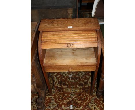 A 1940's Oak roll-top child's Desk, single plank top over the tambour roller with wooden knob, over single drawer, standing o