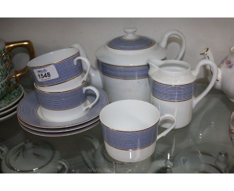 A Limoges Teapot, three saucers and cups and milk jug decorated in blue, white and gilt.