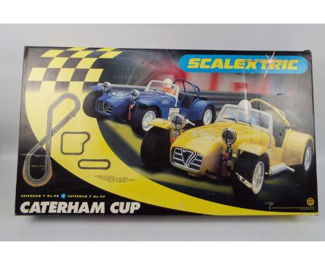Scalextric - A boxed Scalextric Caterham Cup set # C1034. The set show signs of use, one of the cars has a damaged windscreen