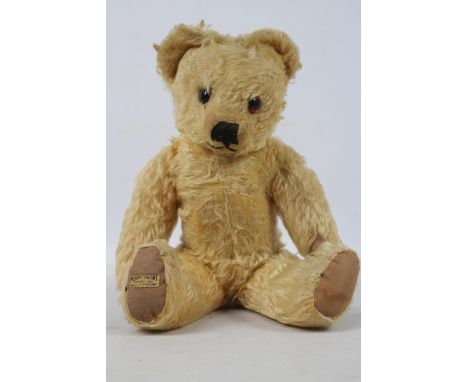 A Merrythought Teddy Bear, 1940s, with golden mohair body, orange and black glass eyes, black vertical stitched snout, mouth,