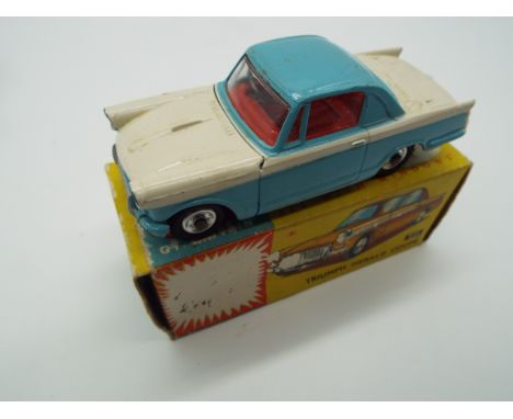 Corgi - a diecast model Triumph Herald Coupe, the bonnet opening to reveal the engine, pale blue and white body, red interior