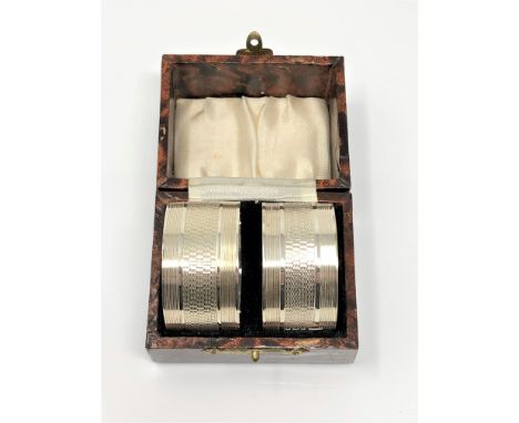 A pair of boxed silver napkin rings with engine turned decoration, London marks CONDITION REPORT: 44.4g