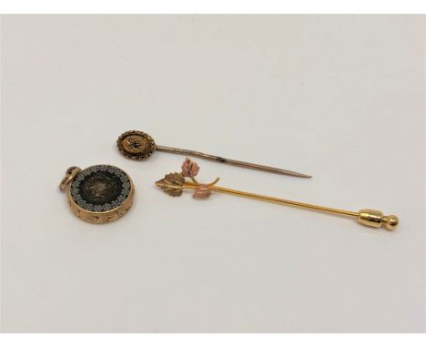 An 18ct gold sapphire and diamond stick pin, a 10ct gold pin and a gold mounted metallic fob (3)