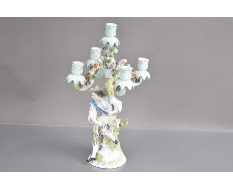 A late 19th-early 20th Century Sitzendorf German porcelain candelabra modelled with shepherd shearing a sheep, Rococo style w
