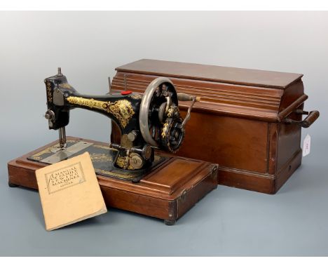 An antique Singer sewing machine, hand-driven, in wooden case together with Singer instruction manual
