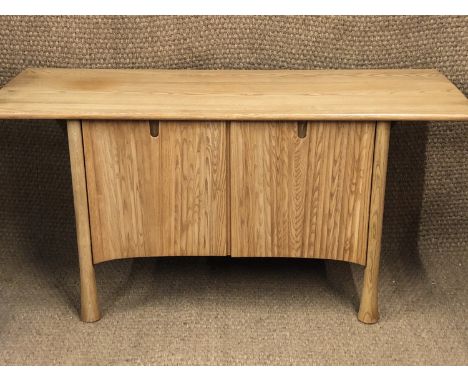 An Ercol Saville pattern elm sideboard, having a shaped plank top, over two cupboard doors and four spreading supports, 150 x