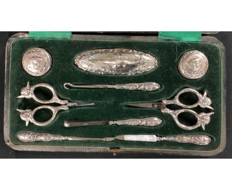 A late Victorian silver mounted manicure set, comprising nail buffer, pair of silver hinged pots embossed with Reynold's ange