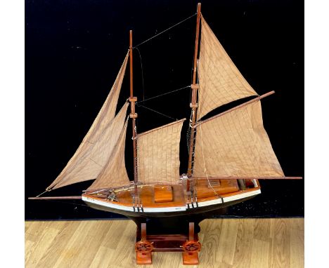 A large model ship, Dolphin London, on wooden stand, 122cm x 125cm; a pair of miniature treen ships wheels (3) 