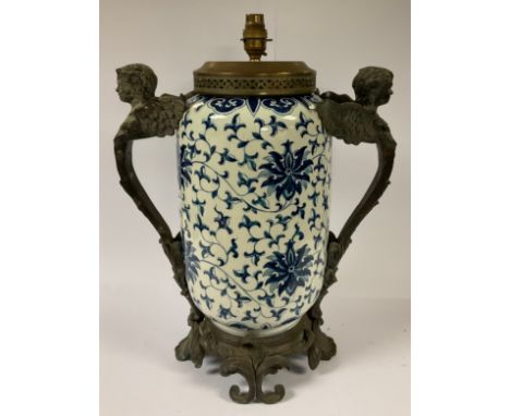 A large bronzed metal mounted table lamp, painted in the Chinese taste in underglaze blue with flowers and scrolling foliage,