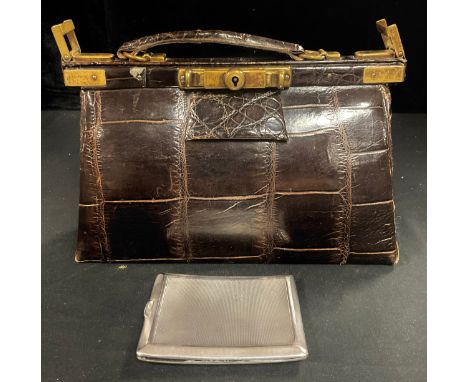 A brown leather crocodile effect handbag, brass sliding clasp, early 20th century; a George V silver cigarette case, engine t