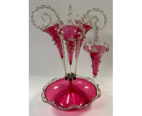 A Victorian cranberry glass epergne, the circular dished base with three cranberry flutes and three clear spirally fluted can