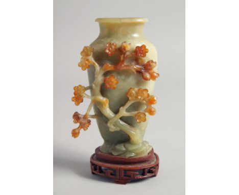 A CHINESE RELIEF CARVED JADE VASE mounted to a hardwood base, the side carved with cherry blossom, 15.5cm high.