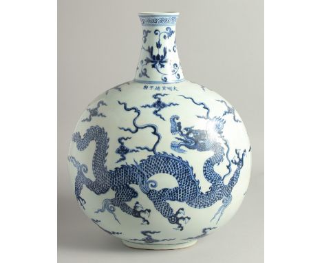 A VERY LARGE CHINESE BLUE AND WHITE PORCELAIN MOON FLASK painted with a large dragon to either side, and stylised clouds, the