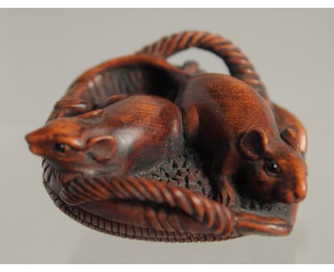 A 19TH/20TH CENTURY JAPANESE CARVED WOOD NETSUKE of two rats in a wicker basket, signed, 3.5cm.