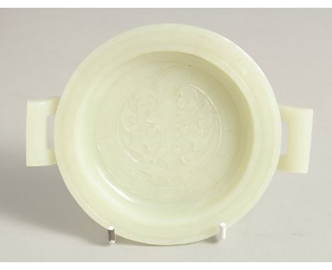 A CHINESE CARVED JADE TWIN HANDLE DISH, with carved central beast motif, 14cm handle to handle.