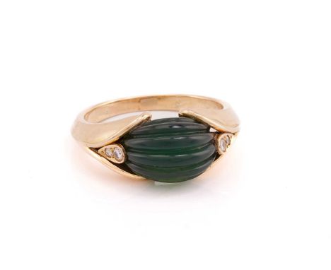Van Cleef and Arpels. A carved green chalcedony and diamond ring; the central fluted oval chalcedony flanked by stylised peta
