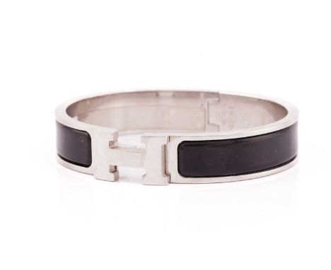 Hermès - A narrow 'Clic H' bracelet with black enamel and white metal, signed and marked, overall measuring 6.2 x 5.5 cm, tot