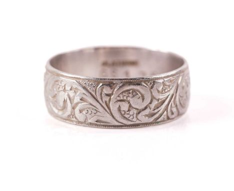 An engraved wedding band, the D-section band has been engraved with scrollwork designs, shank marked 'PLATINUM GS175', ring s