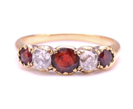 A Garnet and Diamond five-stone ring, set with a central red Garnet flanked by two old round diamonds with an approximate wei