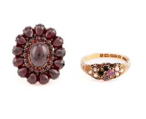 A late 19th / early 20th century yellow gold and garnet cluster ring, centred with a cabochon garnet within a border of small